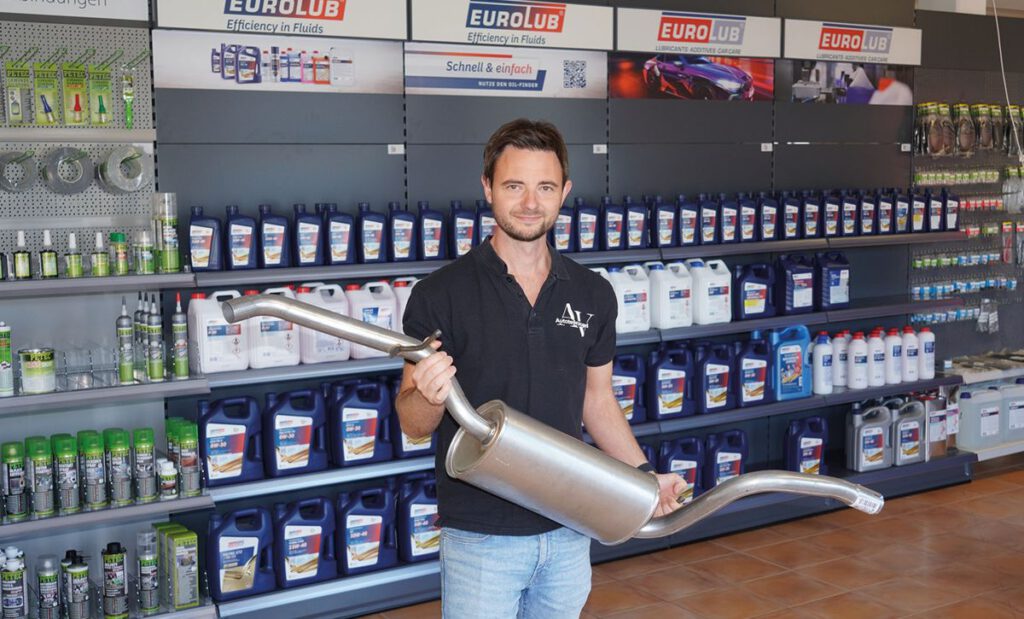 Alexander Vogel mit einer Auspuffanlage im Laden von Autoteile Vogel in Valley